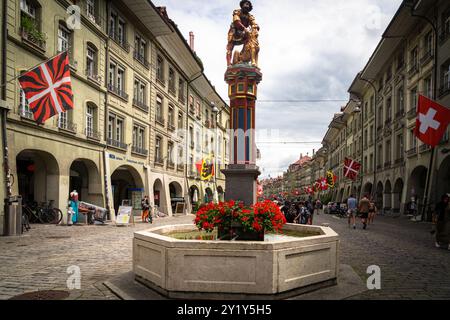 Bern, Schweiz - 22. Juli 2024: Der Simsonbrunnen Brunnen zeigt einen biblischen samson, der einen Löwen tötet, in der überfüllten Marktgasse, einer der Hauptstraßen Stockfoto