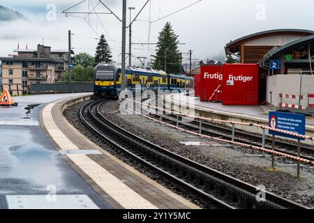 Grindelwald, Schweiz - 22. Juli 2024: Zug kommt am Bahnsteig Grindelwald an, bewölkter Regentag in den Schweizer alpen Stockfoto