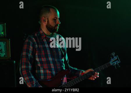 MOGWAI, KONZERT, GREEN MAN FESTIVAL 2012: Dominic Aitchison Bassist mit der schottischen Band MOGWAI Headline live on the Mountain Stage beim Green man Festival 2012 im Glanusk Park, Brecon, Wales, August 2012. Foto: Rob Watkins. INFO: Mogwai ist eine schottische Post-Rock-Band, die für ihre ausgedehnten, instrumentalen Soundscapes bekannt ist. Ihre Musik verbindet ruhige, atmosphärische Momente mit intensiven, gitarrengetriebenen Crescendos und schafft ein emotionales, filmisches Erlebnis, das oft Themen wie Melancholie, Euphorie und Spannung erforscht, ohne sich auf Texte zu verlassen. Stockfoto