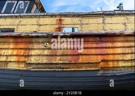 Rostgestreifte Seite eines verlassenen Holzfischbootes am Strand von Hastings, Großbritannien Stockfoto