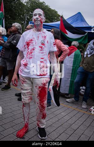 London, Großbritannien. September 2024. Während des Pro-Palästina-Marsches im Zentrum Londons ist ein Demonstrant mit roter und weißer Farbe bemalt. Demonstranten marschierten in Zentral-London, um die britische Regierung aufzufordern, die Lieferung von Waffen an Israel einzustellen und den aktuellen Konflikt in der Region endgültig zu beenden. Quelle: SOPA Images Limited/Alamy Live News Stockfoto