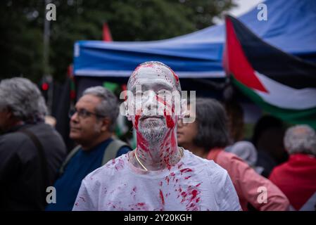 London, Großbritannien. September 2024. Während des Pro-Palästina-Marsches im Zentrum Londons ist ein Demonstrant mit weißer und roter Farbe bedeckt. Demonstranten marschierten in Zentral-London, um die britische Regierung aufzufordern, die Lieferung von Waffen an Israel einzustellen und den aktuellen Konflikt in der Region endgültig zu beenden. Quelle: SOPA Images Limited/Alamy Live News Stockfoto