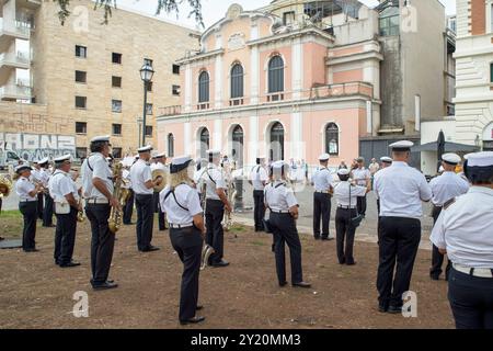 Rom, Italien. September 2024. Die Stadtpolizeikapelle Rom Hauptstadt im Konzert mit dem Theater Ambra Jovinelli im Hintergrund anlässlich der Feierlichkeiten zum 150. Jahrestag des Stadtteils Esquilino in Rom. Das Viertel Esquilino feiert 150 Jahre seit seiner Umwandlung in ein modernes Viertel. Als multiethnisches Viertel und Symbol der kulturellen Integration verdankt es seinen Namen der antiken römischen Kaserne der kaiserlichen Pferdewache, die auf seinem Territorium präsent ist: castra priora equitum singularium. Viele der wichtigen antiken Überreste wurden von der Wohnanlage erstickt Stockfoto