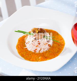 Gebratene Hähnchenherzen, serviert mit Reis und cremiger Tomatensoße Stockfoto