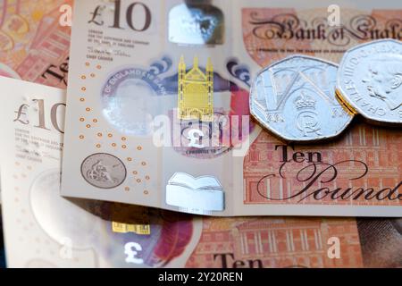 Britische Münzen und Banknoten mit König Karl III., der sich auf die neuen Devisendesigns konzentriert, darunter eine neue 50-Pence-Münze und eine 10-Pfund-Note. Stockfoto