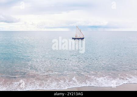 Ein kleines Boot segelt im Meer. Das Boot gleitet über das ruhige Meer unter einem klaren blauen Himmel Stockfoto