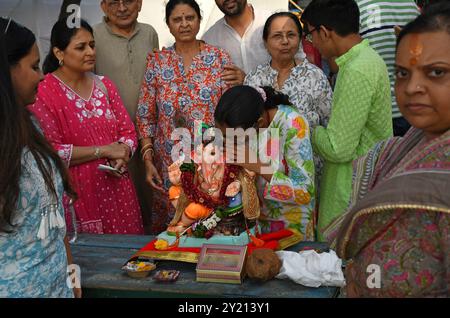 Eine Frau betet zu dem elefantenköpfigen hinduistischen Gott Ganesh, bevor das Idol in Mumbai zum Eintauchen ins Arabische Meer getragen wird. Idole des elefantenköpfigen hinduistischen Gottes Ganesh sind traditionell in einem Gewässer wie See, Fluss oder Ozean eingetaucht, kleinere Idole tauchen in künstlich angelegten Teichen in der ganzen Stadt ein. Das Ritual wird ausgeführt, um den Geburtszyklus von Lord Ganesha zu symbolisieren Stockfoto