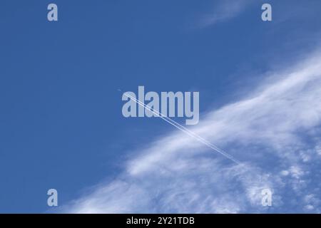 Jet Plane, Contrail und Cirrocumulus Wolken gegen blauen Himmel Stockfoto
