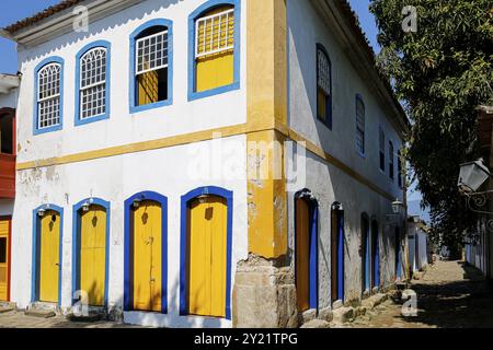 Ecke eines zweistöckigen Kolonialhauses mit farbenfroher Fassade in der späten Nachmittagssonne in der historischen Stadt Paraty, Brasilien, Südamerika Stockfoto