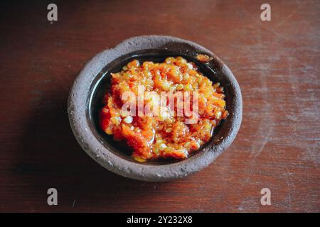 Sambal Bawang oder traditionelle indonesische scharfe Zwiebelsauce mit Zutaten Zwiebeln, roten Chilis, Knoblauch und Salz in einer kleinen Schüssel. Stockfoto