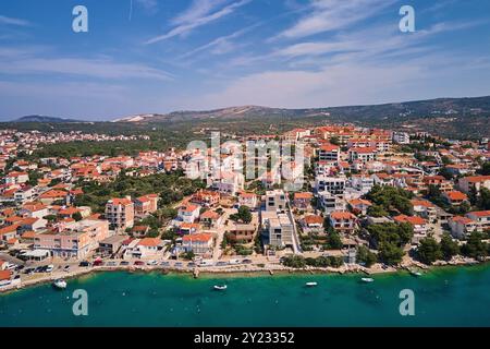 Blick von oben auf die Küste mit türkisfarbenem Wasser und die Küstenstadt mit Häusern mit roten Dächern. Panorama der touristischen Stadt Rogoznica in Kroatien an der Adria SE Stockfoto