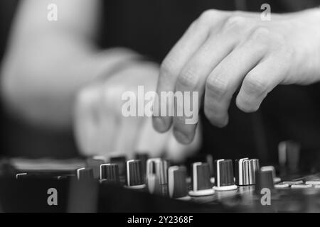 DJ Set Control Close-Up: Hand-on-Ausrüstung in Schwarzweiß Stockfoto