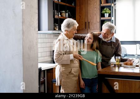 Liebevolle Seniorengroßeltern in der Küche in Kinder verliebt Stockfoto