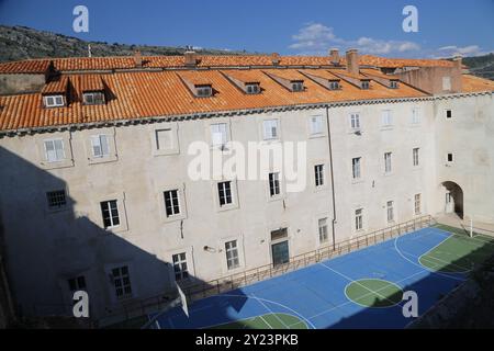 Dubrovnik, Kroatien, Altstadt, gekacheltes Dach eines Hauses altes Steingebäude mit einer dreieckigen Fassade, Blick von oben, Leute Touristen gehen 22. April 2023. Stockfoto