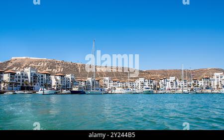 Blick auf den Yachthafen von Agadir in Marokko. Beliebte Touristengegend mit Luxuswohnungen, Booten im Hafen, Geschäften und Restaurants. Marokkanisches Baderesort Stockfoto