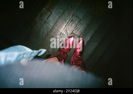 Die leuchtend pinken Cowboy-Stiefel über dem Kopf Stockfoto
