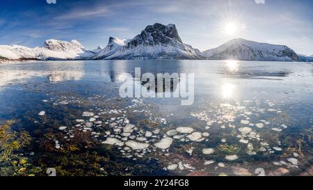 Schneebedeckte Berge entlang eines gefrorenen Fjords Stockfoto