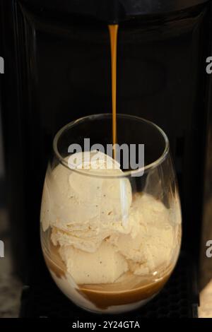 Affogato mit Espresso, das über Vanilleeis in einem Glas gießt Stockfoto