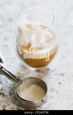 Affogato in einem Glas mit geschmolzenem Eis und einer Schaufel an der Seite Stockfoto