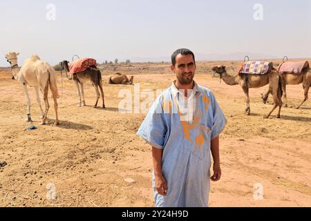 Nomadenlager mit Dromedaren und Kamelfahrer in der Wüstenlandschaft nahe dem Mittleren Atlas in Marokko. Marokko, Nordafrika. Foto von Hug Stockfoto