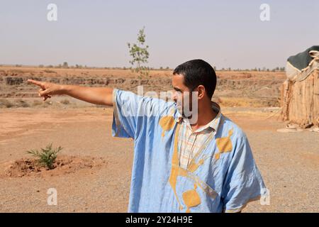 Nomadenlager mit Dromedaren und Kamelfahrer in der Wüstenlandschaft nahe dem Mittleren Atlas in Marokko. Marokko, Nordafrika. Foto von Hug Stockfoto