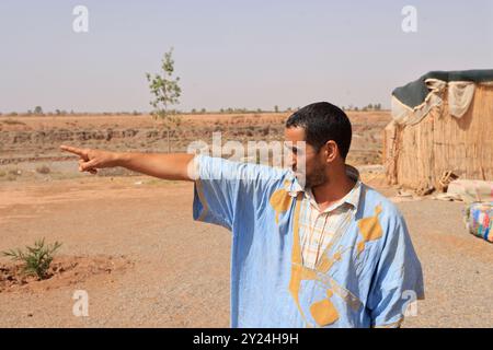 Nomadenlager mit Dromedaren und Kamelfahrer in der Wüstenlandschaft nahe dem Mittleren Atlas in Marokko. Marokko, Nordafrika. Foto von Hug Stockfoto