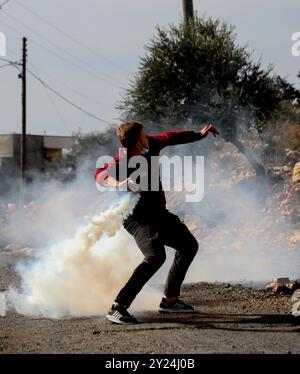 Qalqilya, Westjordanland, Palästina. Dezember 2021. Israelische Soldaten stoßen mit palästinensischen Jugendlichen zusammen, die in der Stadt Kafr Qaddum im Westjordanland im Gouvernement Qalqilya protestieren. Palästinenser in der Westjordanstadt Kafr Qaddum führen seit 2011 wöchentliche Demonstrationen gegen Landbeschlagnahmen durch nahe gelegene jüdisch-israelische Kolonien und gegen die Schließung der Straße zwischen Kafr Qaddum und der nahe gelegenen Stadt Nablus durch. Nach dem Völkerrecht gelten alle jüdisch-israelischen Siedlungen im Westjordanland und Ostjerusalem als illegal Stockfoto