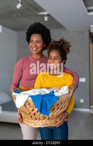 Die schwarze Tochter hilft Mutter, Haushalts- und Hausarbeiten zusammen zu erledigen Stockfoto