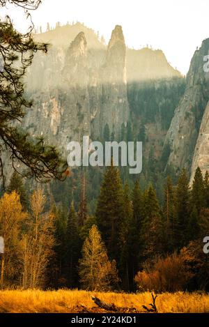 Licht filtert durch die nebeligen Klippen der Three Brothers in Yosemite Stockfoto