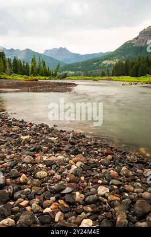 Der Fluss fließt über bunte Steine in Yellowstone. Stockfoto