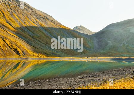 Wunderschöner Kelitsadi See und Zelte am Ufer mit Menschen am frühen Morgen vor der Wanderung. Gruppentouren in den Bergen des Georgien kaukasus Stockfoto