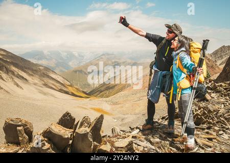 Close Up junge glückliche kaukasische aktive Millennial Paare Influencer machen Smartphone-Selfie, während sie Spaß auf einer Wanderung in die Natur haben und Berge erreichen Stockfoto