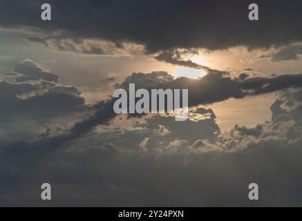 Die Sonnenstrahlen, die durch die Wolken hindurchgehen und strahlen, bilden ein interessantes Lichtmuster am Himmel. Atemberaubende Farben Himmel und Wolken als Hintergrund Stockfoto