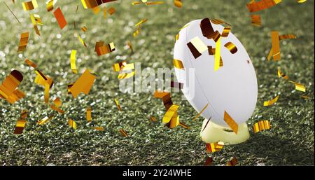 Bild von Konfetti über weißem Rugbyball auf Gras Stockfoto