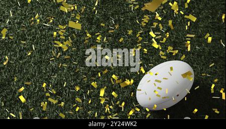 Bild von Konfetti über weißem Rugbyball auf Gras Stockfoto