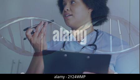 Bild eines dna-Strangs über afroamerikanischer Ärztin, die auf dem Smartphone spricht Stockfoto
