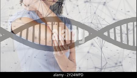 Bild von dna-Strang und Verbindungen über afroamerikanerin, die ihren Ellenbogen hält Stockfoto