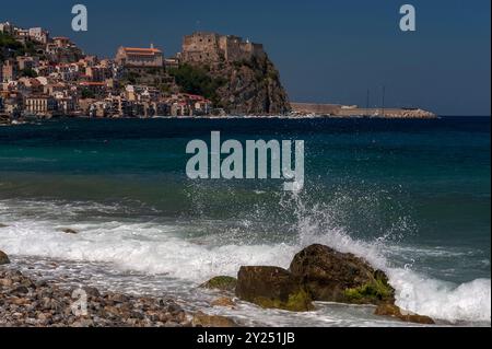 Auf einem Felsvorsprung mit Blick auf das Tyrrhenische Meer und die Meerenge von Messina, eine mittelalterliche Burg, das Castello Ruffo di Calabria und links von der Burg die Stadt Scilla in Kalabrien, Italien. Der griechischen und römischen Legende nach spukte das Meeresungeheuer Scylla hier, gegenüber dem Whirlpool Charybdis. Unmittelbar links von der Burg befindet sich eine Kirche, die in den 1950er Jahren wieder aufgebaut wurde, die Chiesa dell’Immacolata. Stockfoto