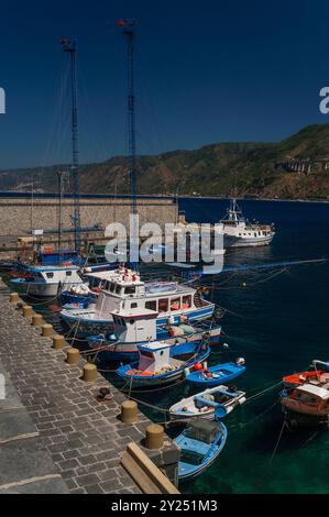 Sommer in Scilla, einer Stadt in Kalabrien, Italien, mit Blick auf das Tyrrhenische Meer und die Meerenge von Messina. Von Mai bis August machen sich Fischer auf den Weg, um Schwertfisch in der Meerenge in speziell entwickelten Schwertfisch-Fischerbooten zu fangen, wie diese, die jeweils einen hohen Mast mit einer Aussichtsplattform und, Meter von der Vorderseite des Bootes entfernt, eine lange Eisenbrücke, bekannt als passarella, die als Harponierplattform dient. Stockfoto