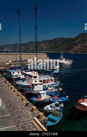 Speziell entworfene Schwertfisch-Fischerboote im Hafen von Scilla, einer Stadt in Kalabrien, Italien, mit Blick auf das Tyrrhenische Meer und die Meerenge von Messina. Jedes Boot hat einen hohen Mast mit einer Aussichtsplattform und, Meter von der Vorderseite des Bootes entfernt, eine lange Eisenbrücke, bekannt als passarella, die als Harponierplattform dient. Von Mai bis August machen sich Fischer auf den Weg, um Schwertfisch in der Straße zu fangen. Stockfoto