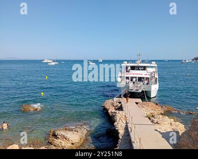 Palmanova, Spanien; 10. august 2024: Ausflugsboot mit Touristen an der felsigen Küste des mallorquinischen Kurortes Palmanova, auf einer sonnigen Insel Stockfoto