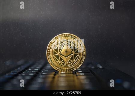 Ethereum-Goldmünzen auf futuristischem und abstraktem Hintergrund über schwarzer Laptop-Tastatur. Finanz- und Investitionskonzept. Stockfoto