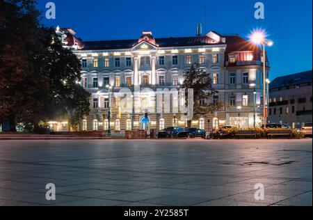 Wunderschön beleuchtetes historisches Gebäude im Herzen der Innenstadt mit bewegten Menschen in der Nacht. Reisetrend für Chill-Destinationen. Vilnius, Lith Stockfoto