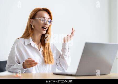 Eine Geschäftsfrau, die in einem Videogespräch in einem Büro mit Kollegen spricht. Eine Geschäftsfrau, die ein Online-Meeting mit ihrem Team abhält. Professionelle Geschäftsfrau Stockfoto