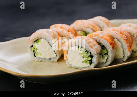 Shrimps Sushi-Brötchen Philadelphia mit cremiger Füllung und Gurke sowie Themen der japanischen Küche Stockfoto