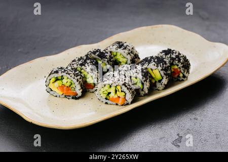 Sushi-Brötchen mit schwarzem Kaviar und frischem Gemüse, ideal für japanische Küche und Lebensmittelfotografie Stockfoto