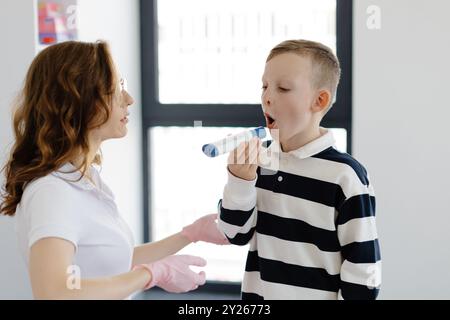 Pädiatrischer Pulmonologe hilft dem Jungen mit Peak Flow Meter. Pulmonologe, Arzt, der auf die Diagnose und Behandlung von Krankheiten spezialisiert ist und Stockfoto