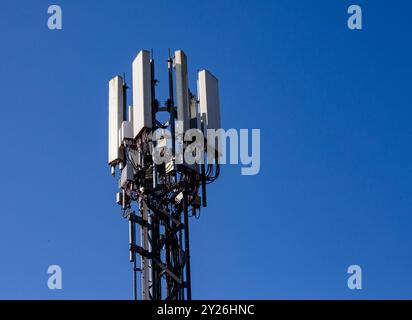 Die Spitze eines Telekommunikationsturms vor einem klaren blauen Himmel. Stockfoto