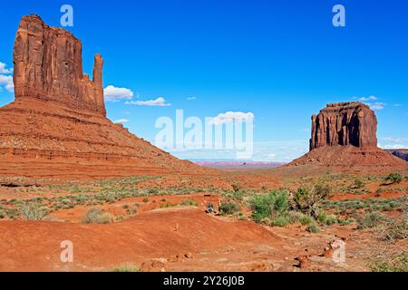 Zwei Wanderer auf dem Weg vorbei an West Mitten und Merrick Buttes im Monument Valley Stockfoto