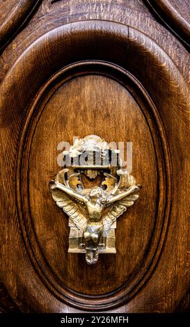 Der aufwendig gestaltete Türklopfer zeigt einen anmutigen Engel mit ausgestreckten Flügeln, der Besucher zu einem Stück Pariser Eleganz einlädt, das von ihm durchdrungen ist Stockfoto